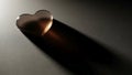 Heart-shaped translucent object rests on a textured surface, casting Royalty Free Stock Photo