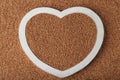 Heart shaped tray with uncooked buckwheat on grains Royalty Free Stock Photo