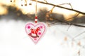 Heart shaped Valentines or Christmas decoration toy hanging on the tree branch with snow on the background Royalty Free Stock Photo