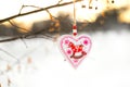 Heart shaped Valentines or Christmas decoration toy hanging on the tree branch with snow on the background Royalty Free Stock Photo