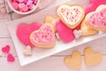 Heart shaped Valentines Day cookies with pink and white icing, overhead on a plate against white wood Royalty Free Stock Photo