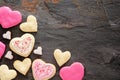 Heart shaped Valentines Day cookies with pink and white icing, top view corner border over a dark background Royalty Free Stock Photo