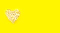 Heart shaped white fluffy popcorn on yellow background Royalty Free Stock Photo