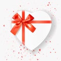 Heart shaped white Gift Box tied with Red Ribbons with a Bow on white background with heart shaped confetti. Top view. Greeting Royalty Free Stock Photo