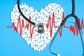 Heart of white pills and stethoscope on blue background Royalty Free Stock Photo