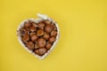 Heart-shaped wicker basket full of chestnuts Royalty Free Stock Photo