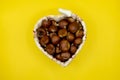 Heart-shaped wicker basket full of chestnuts Royalty Free Stock Photo