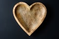 Heart shaped wooden bowl on a black background, rustic happy ValentineÃ¢â¬â¢s Day