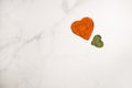 Heart shapes of dried basil and paprika powder spices on marble background