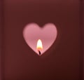 Heart shapes hole cut out on dark red background burning candle light on pink backdrop, romantic, meditation