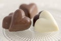 Heart shapped chocolate sweets, brown and white color, transparent retro plate with pralines