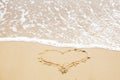 Heart sign on beach. Heart symbol on sandy beach and sea waves with foam. Love and hello summer concept. Vacation, relax and Royalty Free Stock Photo