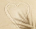 Heart Sign painted on the sand and palm leaf shadow Royalty Free Stock Photo