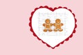 Heart with smiling gingerbread man and woman on completed white jigsaw puzzle, isolated on pink background, copy space Royalty Free Stock Photo