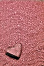 Heart stone on wavy pink sand Royalty Free Stock Photo