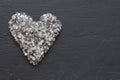 Heart of stones, love. Scattered diamonds on black background. Raw diamonds and mining, a scattering of natural diamond stones. Royalty Free Stock Photo