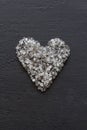 Heart of stones, love. Scattered diamonds on black background. Raw diamonds and mining, a scattering of natural diamond stones. Royalty Free Stock Photo