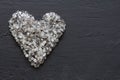 Heart of stones, love. Scattered diamonds on black background. Raw diamonds and mining, a scattering of natural diamond stones. Royalty Free Stock Photo