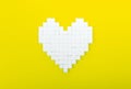 Heart of sugar cubes, yellow background