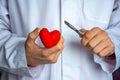 Heart surgery or cardiac surgery cardiosurgery. Doctor surgeon holding scalpel in hand and cut red heart shape on white backgrou