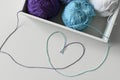 Heart symbol designed from colorful threads out of white box, with knitting yarn balls. Royalty Free Stock Photo