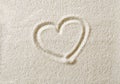 Heart symbol drawn in sand surface macro photo