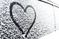 Heart symbol on frozen window of the car. Shape of heart drawn on snow on front window of the car. Heart snow. Christmas decoratio Royalty Free Stock Photo