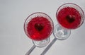 Heart symbol inside crystal glasses with red alcoholic drink for two