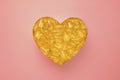 Heart symbol made of omega fish oil capsules on pink background. Cholesterol free heart health concept Royalty Free Stock Photo