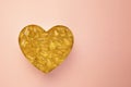 Heart symbol made of omega fish oil capsules on pink background. Cholesterol free heart health concept with copy space Royalty Free Stock Photo