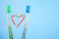 The heart symbol is made from a three-color toothpaste and is located between two toothbrushes Royalty Free Stock Photo
