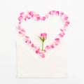 Heart symbol with roses flowers with envelope on white background. Valentines day. Flat lay, top view Royalty Free Stock Photo