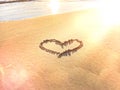 Heart symbol on  sunset  beach sand  and  sea water  reflection light nature landscape romantic  summer  background Royalty Free Stock Photo