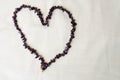 Heart for Valentine`s Day made of female beautiful beads, necklaces of brown dark stones, amber against a background of beige fab Royalty Free Stock Photo