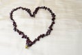 Heart for Valentine`s Day made of female beautiful beads, necklaces of brown dark stones, amber against a background of beige fab Royalty Free Stock Photo