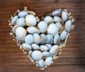 Heart from white corals and shells on wooden background. Handmade love decor from beach finding.