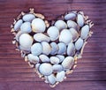 Heart from white corals and shells on wooden background. Handmade love decor from beach finding.