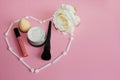 Heart of white shadow applicators on a pink background inside the heart lipstick, powder and black powder brush Royalty Free Stock Photo