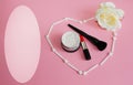 Heart of white shadow applicators on a pink background inside the heart lipstick, powder and black powder brush and next to a whit Royalty Free Stock Photo