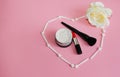 Heart of white shadow applicators on a pink background inside the heart red lipstick, powder and black powder brush  r Royalty Free Stock Photo