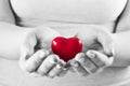 Heart in woman hands. Love giving, care, health, protection. Royalty Free Stock Photo