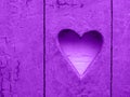 Heart on wooden rustic wall. Heart sign, hole. Dark orchid colour. dark orchid color heart pattern