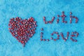 Heart and words with love made from pomegranate seeds on a blue textural background Royalty Free Stock Photo