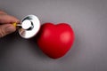 Heartbeat and health check. red rubber heart and stethoscope on a gray background Royalty Free Stock Photo
