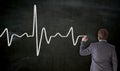 Heartbeat is painted on blackboard by businessman Royalty Free Stock Photo