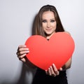 Heartbreaker. Temptress. Seductive woman. Portrait of amazing young fashion woman posing at studio with red heart. Love. Valentine Royalty Free Stock Photo