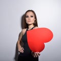 Heartbreaker. Temptress. Seductive woman. Portrait of amazing young fashion woman posing at studio with red heart. Love. Valentine Royalty Free Stock Photo