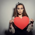 Heartbreaker. Temptress. Seductive woman. Portrait of funny pinup young fashion woman posing at studio with red heart. Love.