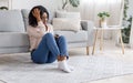 Heartbroken Girl. Crying Black Woman Sitting With Smartphone On Floor At Home Royalty Free Stock Photo