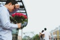 Heartbroken man holding bouquet of red roses feeling sad while s Royalty Free Stock Photo